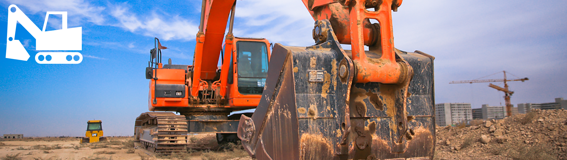 Construction-hero_1920x542 Close-up view of an orange excavator on a construction site with dirt in the bucket, a yellow roller compactor in the background, cranes, and buildings under a blue sky. A white excavator graphic appears in the top left corner.