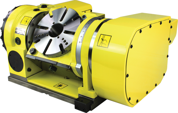turnkey A yellow industrial rotary table with a circular faceplate and clamping jaws, used in CNC machining for precisely rotating workpieces. The table has safety warning labels and protective casing.