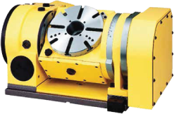 rotary-table A yellow CNC rotary table with a circular metal plate featuring evenly spaced slots, mounted on a rectangular base with mechanical components visible.