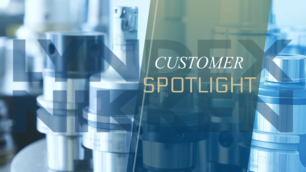 Close-up of industrial metal machinery parts in cool tones, overlaid with the words CUSTOMER SPOTLIGHT in white and gold text. The background features blurred cylindrical components, highlighting high quality machining and enhanced rigidity.