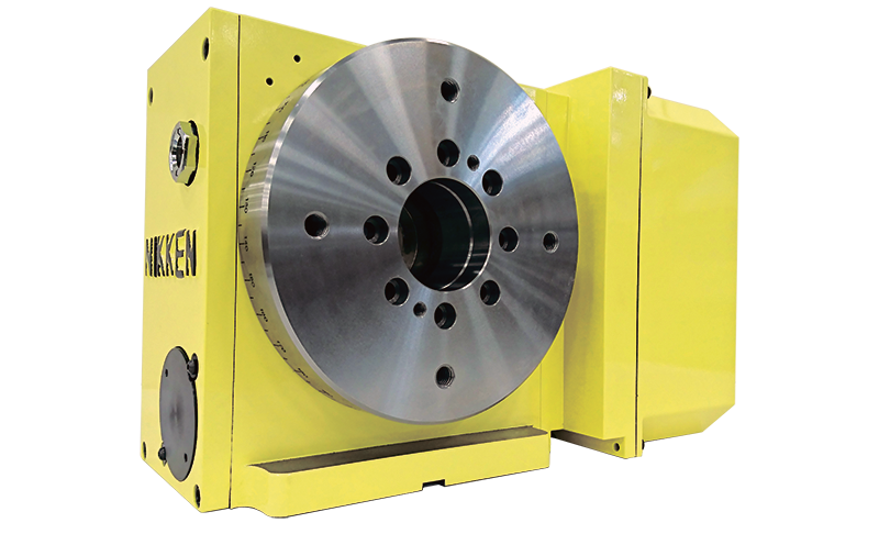 Nikken-Rotary-Table-NCT200_800x486 A yellow Nikken NCT200 rotary table with a metallic circular faceplate featuring multiple holes, used for precision positioning in machining and manufacturing processes. The device is set against a plain white background.
