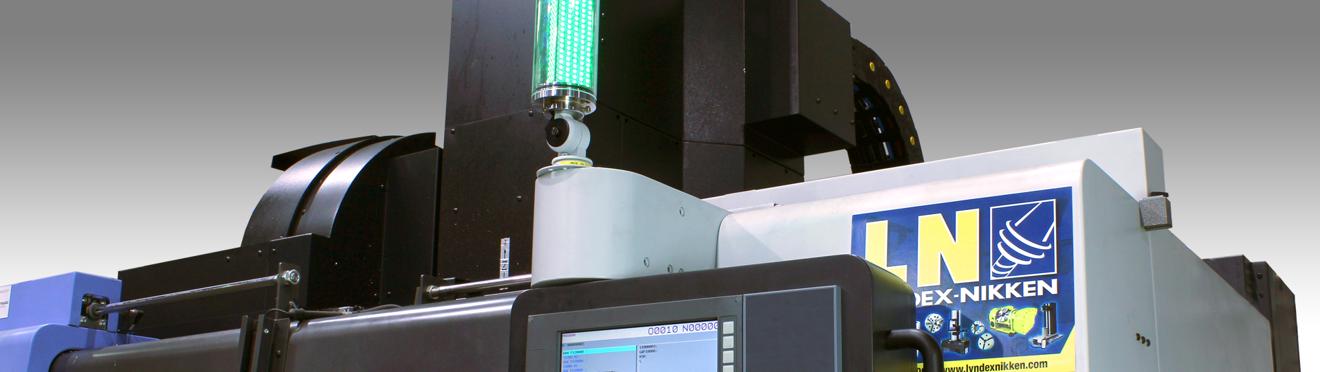 Solutions-Main-hero_1920x542 A close-up view of industrial machinery with a digital display screen, a green indicator light, and a LN NIKKEN sign attached to the equipment.