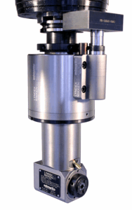 A close-up view of a  Lyndex Nikken right angle head, featuring cylindrical metal components and engraved identification labels. The device appears clean and well-maintained.