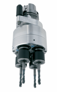 A close-up view of a multi-spindle drilling head attachment with four spiral drill bits and a metallic cylindrical body, photographed against a white background.