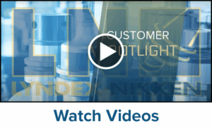 A video thumbnail features industrial machine parts in blue tones, highlighting SK Collet Chucks with overlaid text reading Customer Spotlight and Lyndex-Nikken. A play button appears in the center. Below, text says Watch Videos.