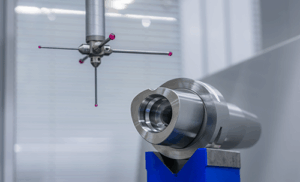 A coordinate measuring machine probe inspects a PSC Polygonal tool holder, which is mounted on a blue stand in a clean, industrial environment.
