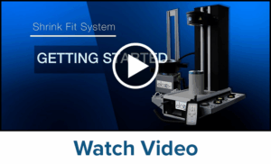 Screenshot of a video titled Shrink Fit System Getting Started showing an industrial shrink fit machine against a blue background, with a play button icon overlay and the text Watch Video below.