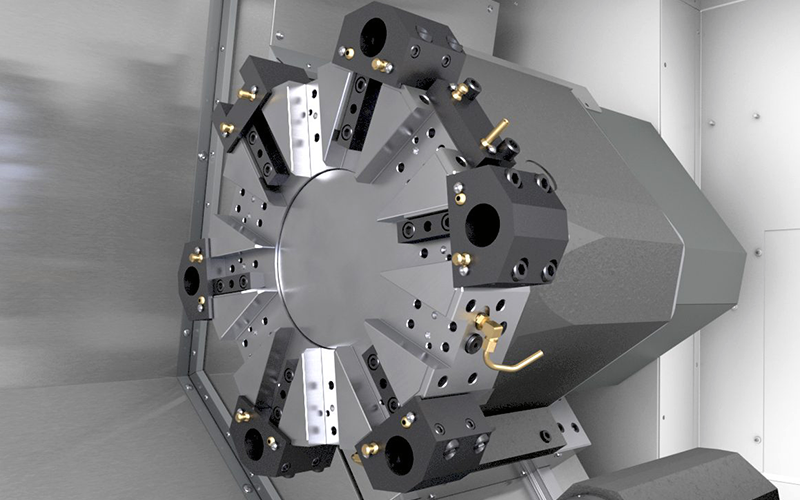 A close-up view of a CNC lathe turret with multiple tool holders, mounted on a metallic panel inside a machining enclosure.