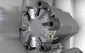 Close-up view of a CNC lathe turret with multiple tool holders arranged in a circular pattern, mounted inside the machines metallic enclosure.