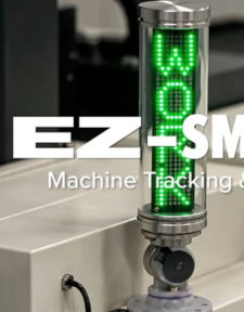 A vertical LED signal light displays the word WORK in green. The background includes industrial equipment and partially visible white text reading EZ-SM Machine Tracking &..